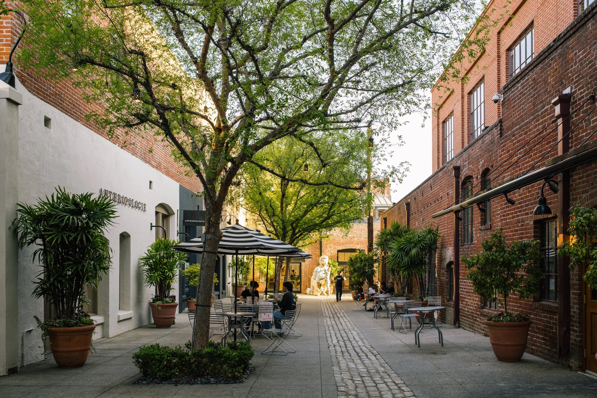 Restored brick storefronts and pedestrians along East Colorado Boulevard near Raymond Avenue in Old Pasadena.