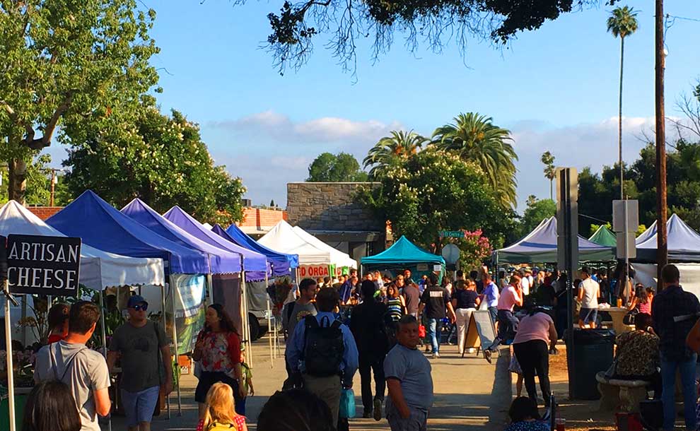 Shoppers browsing produce stands at the Saturday farmers market at Victory Park